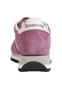 Sneakers Saucony in morbido suede rosa chiaro con accenti e logo bianchi. Presentano un contrafforte per il supporto del tallone e una suola in gomma per la trazione.