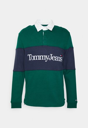 Zielona koszulka rugby z długim rękawem, granatowym poziomym paskiem, białym kołnierzykiem i logo "Tommy Jeans" na piersi.
