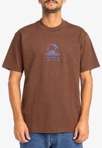 Brown cotton t-shirt featuring a blue graphic design with a skull and world motif, crew neck, and short sleeves.