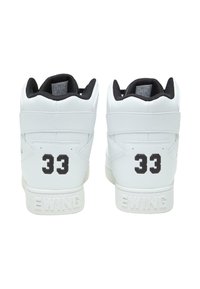 White high-top sneakers feature a smooth leather finish, black accents, number "33" on the heel, and "EWING" embossed on the sole.