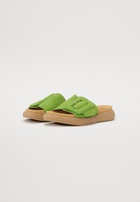Žalia suede skaidriųjų sandalai su paminkštintu viršumi, rudi guminiai padas ir paprasta iškirpimo dizainas. Glotni tekstūra su minimaliais detalių. 