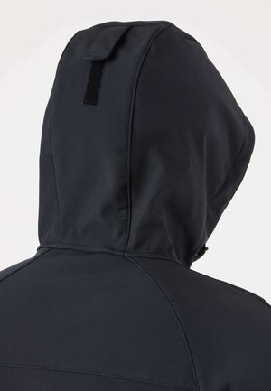 Veste noire à capuche vue de dos avec un design de couture visible et un petit patch rectangulaire en Velcro sur la capuche.
