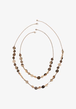 Dve plasti ogrlic zlatega verižnega nakita z enakomerno razporejenimi okroglimi obeski v obliki diska na belem ozadju.