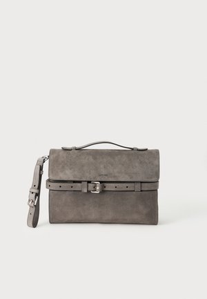 Sac à main rectangulaire en daim gris avec poignée supérieure, sangle réglable à boucle et fermeture à rabat ceinturée sur fond blanc.
