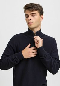 Pulover navy din tricot texturat, cu fermoar la jumătate, cu manșete ribbate și un fermoar elegant, oferind o siluetă ajustată și un aspect modern.