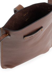 Brun lædertaske med åbent top, der har en glat overflade, simpel design og kontrasterende syninger. Indeholder et mærketag.