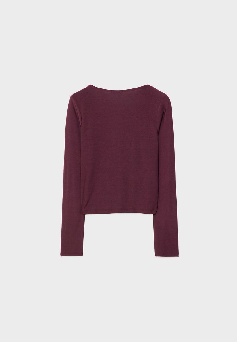 Maglia bordeaux a maniche lunghe con taglio corto, scollo rotondo e texture liscia. Nessun motivo visibile o dettagli hardware.