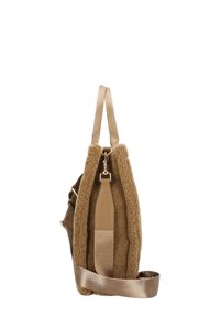 Tan schapenvacht tote bag met dubbele stofhandvatten en een afneembare brede satijnen schouderriem, zijaanzicht.
