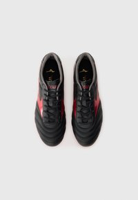 Pantofi sport negri și roșii din piele netedă și texturată. Caracteristici includ un design cu șireturi, guler căptușit și accente cu logo pe laterale.