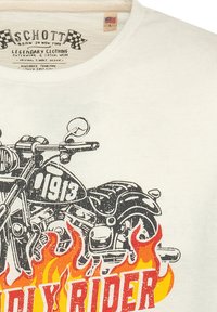 Witte katoenen t-shirt met een afbeelding van een motorfiets met "1913" en "BADLY RIDER" in het rood, omringd door vurig oranje vlammen.