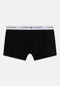 Black cotton boxers with a white elastic waistband featuring "TOMMY HILFIGER" logo. Machine-stitched seams and a front pouch design.