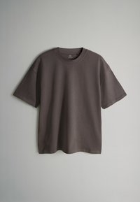 Ciemnoszara koszulka z krótkim rękawem o okrągłym dekolcie i luźnym kroju. Wykonana z miękkiego materiału o gładkiej fakturze. Prosty design, bez wzorów.