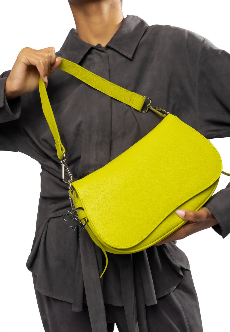 Limegrünes Leder-Umhängetasche mit geschwungener Silhouette, verstellbarem Tragegurt, silbernem Zubehör und einem kleinen Logo-Akzent.