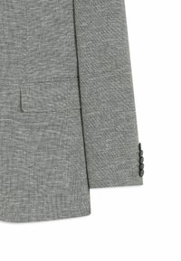 Manche de veste de costume grise texturée avec quatre boutons noirs et une poche à rabat sur le panneau avant sur fond blanc.