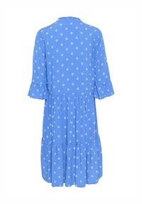Blå prickig klänning med ett lager-på-lager design, trekvartslånga ärmar och en volangkrage. Materialet verkar lätt och mjukt.