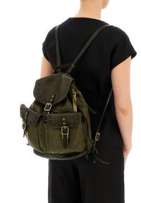 Zaino in pelle verde oliva con cuciture decorative, numerose tasche e hardware color oro, indossato sulla schiena di una persona.