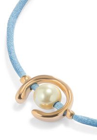 Collar de cordón textil azul que presenta una gran perla crema lustrosa y un acento de metal dorado suave en un diseño curvo.