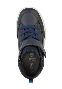 Sneaker grigio scuro con accenti blu, realizzato in pelle liscia. Presenta una striscia in velcro, lacci intrecciati e una suola testurizzata.