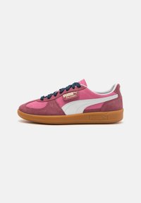 Sneakers Puma Palermo mají svršek z růžové a tmavě červené suede kůže, bílé detaily, námořnické šněrování a gumovou podrážku s bočním logem značky.