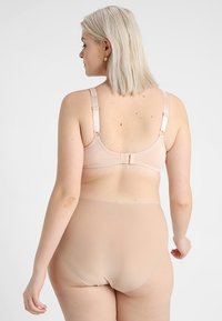 Light beige lingerie set featuring a bra with adjustable straps and hook closure, paired with high-waisted, seamless underwear.