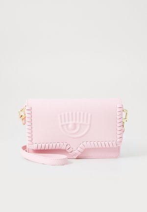 Clutch de cuero rosa claro con diseño de ojo en relieve, detalles de costura látigo en los bordes y correa de muñeca desmontable con herrajes dorados.