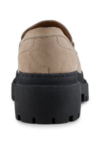 Suede shoe in light beige with a thick black rubber sole. Features a solid heel and contrasting stitching along the back.