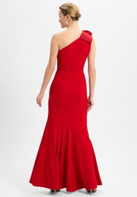 Rotes, einseitig getragenes Abendkleid mit tailliertem Oberteil und ausgestelltem Saum. Es verfügt über eine Schleifenakzentuierung an der Schulter und einen glatten, dehnbaren Stoff.