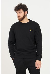 Felpa nera in una vestibilità rilassata, realizzata in cotone spesso. Presenta un collo rotondo e un piccolo logo dorato sul petto.
