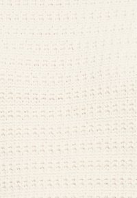 Tissu tissé de couleur beige clair avec un motif texturé comportant des rangées alternées de petits points en relief. Matériau doux et flexible.