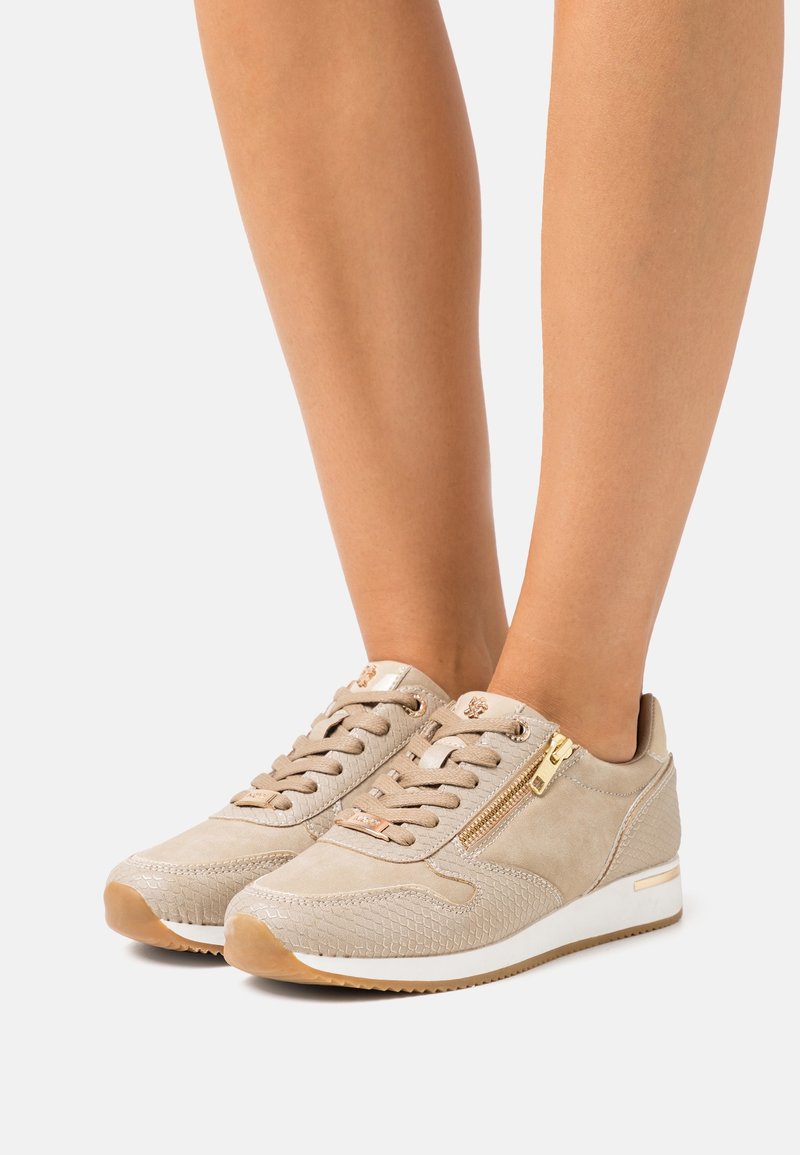 Baskets en daim beige avec des accents texturés, un détail de fermeture éclair dorée et une semelle en caoutchouc. Design à lacets avec une coupe basse et un bout arrondi.