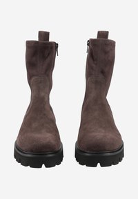 Bottines en daim marron avec une fermeture éclair sur le côté et une semelle en caoutchouc noir robuste avec un motif de crampons texturé.