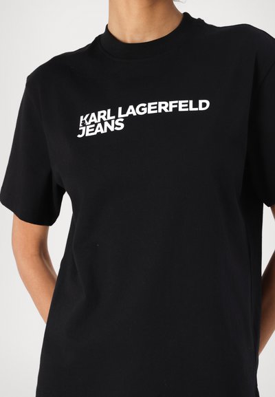 Черен памучен потник с бяло отпечатано лого, което гласи "KARL LAGERFELD JEANS." Класически кръгъл врат и къси ръкави.