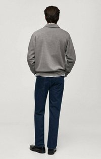 Grå sweatshirt med långa ärmar, avslappnad passform och ribbade ärmar, i kombination med mörkblå jeans och svarta skor. Bakvy.