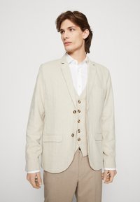 Beige, texturerad kavaj i lätt tyg, med slagkrage, enkel knäppning och två framfickor.
