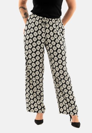 Pantaloni larghi a righe bianchi e neri con un design a diamante, dotati di cintura elastica e cordino. Adatti per un abbigliamento casual.