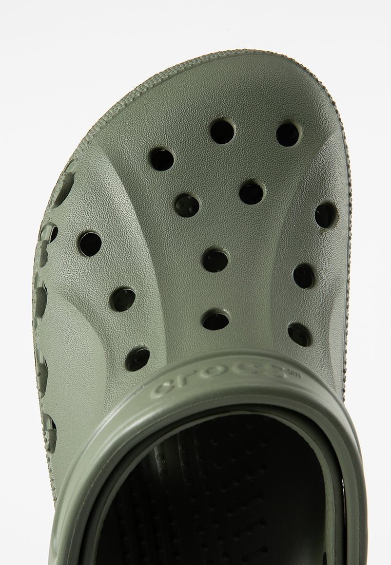 Sabots Crocs verts en matériau léger, dotés de trous de ventilation, d'une semelle épaisse et d'un intérieur texturé pour le confort.