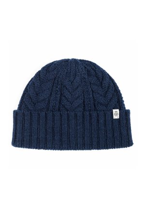 Navy blue knit beanie featuring a textured cable pattern, ribbed cuff, and a small brand tag on the side. Soft wool blend material.