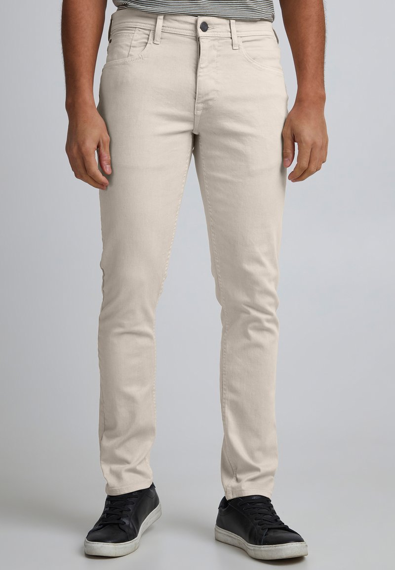 Jeansi bej deschis, croială slim, confecționați dintr-un amestec de bumbac, cu cinci buzunare și închidere cu fermoar. Stilizați cu o textură subtilă.
