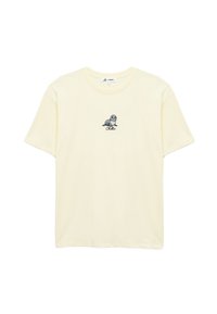 Vaaleankeltainen puuvillat-paita, jossa on pieni kuvasto hylkeestä ja teksti "Chillin" sen alla, perinteisessä pyöreässä kauluksessa.