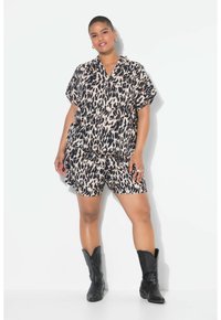 Camicia a maniche corte con stampa leopardata e pantaloni corti coordinati in beige e nero, caratterizzati da una vestibilità rilassata e tasche, abbinati a stivali cowboy neri.