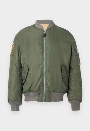 Veste bomber vert olive, en nylon, fermeture éclair, poignets et ourlet côtelés, poches latérales, détail de patch sur l'épaule, logo sur la poitrine.