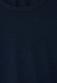 Tastă de bumbac de culoare bleumarin, cu o textură netedă și un design clasic cu guler rotund, având variații subtile în culoare și fir.