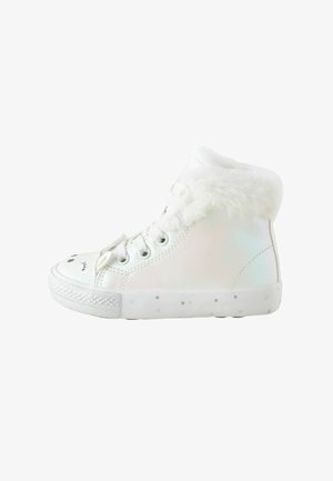 Zapatillas altas en material blanco iridiscente con forro de piel en el cuello, con acentos de patrón estelar en la suela y un diseño de cara juguetón.
