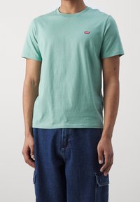 T-shirt vert menthe à manches courtes en coton, avec un col rond et un petit logo Levi's rouge sur la poitrine gauche.