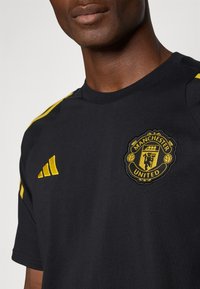 adidas Performance MANCHESTER UNITED 25/26 EUROPEAN COTTON TEE - Article de supporter d'équipe de club - black/tribe yellow