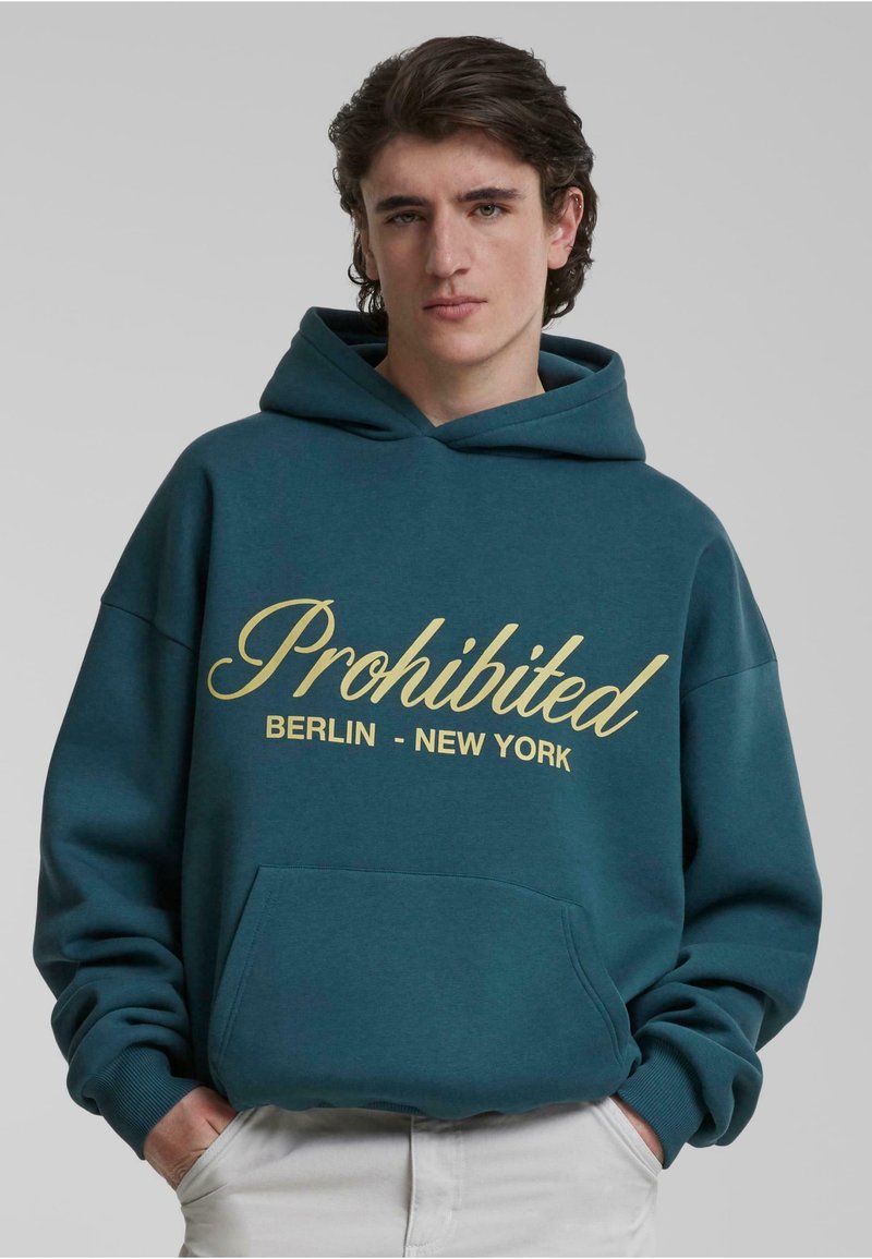 Teal hættetrøje lavet af blød stof, med en frontlomme og tekst i skriftskrift "Forbudt BERLIN - NEW YORK" i gul. Justerbar snøre hætte.