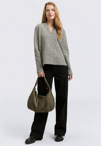 Gray patterned pullover with a V-neckline, paired with black wide-leg pants and a dark green slouchy handbag. Flat black shoes complete the look.