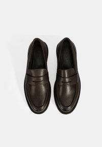 Braune Lederloafer mit strukturiertem Finish, breitem Riemenakzent und einer runden Zehenform mit flacher Gummisohle.