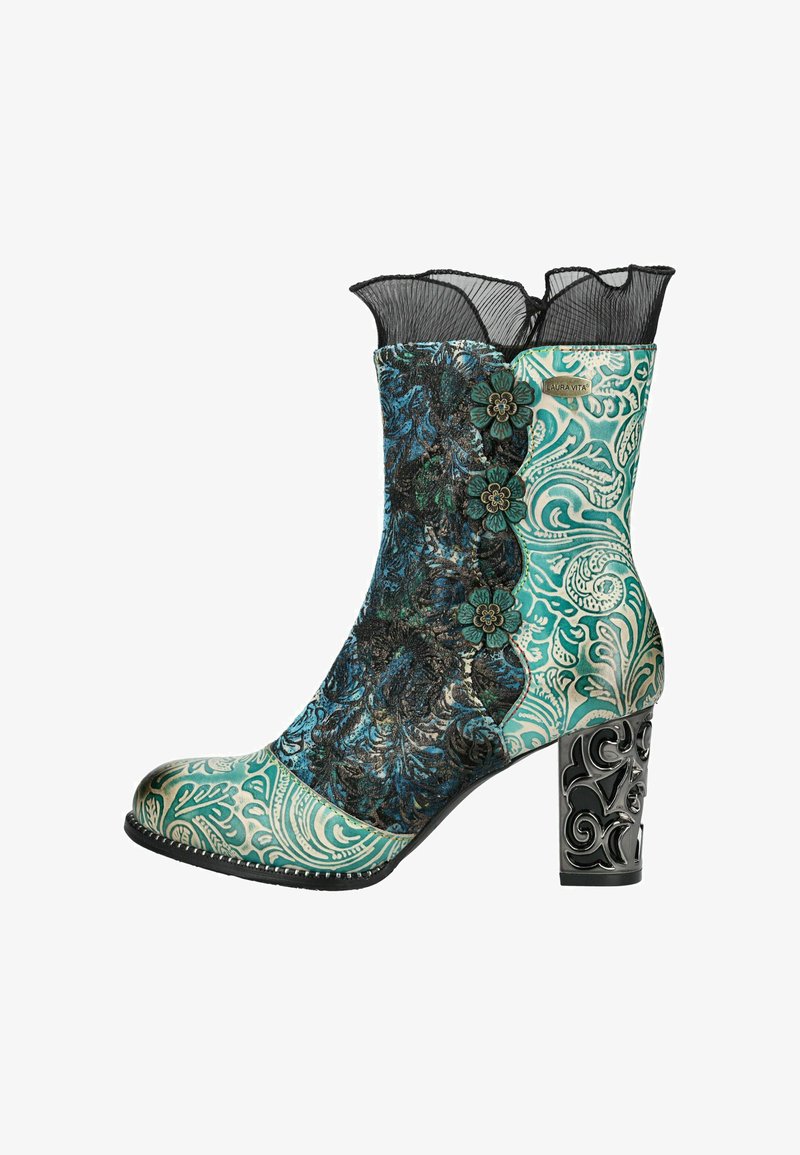 Botín con parte superior de color teal y negro estampado, acentos florales y un ribete de encaje negro. Presenta un tacón decorativo con un diseño intrincado.