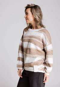 Gestreifter Pullover in Beige und Weiß, aus weichem Material gefertigt, mit Rundhalsausschnitt, lockerem Schnitt und einem kleinen Etikett auf der linken Unterseite.